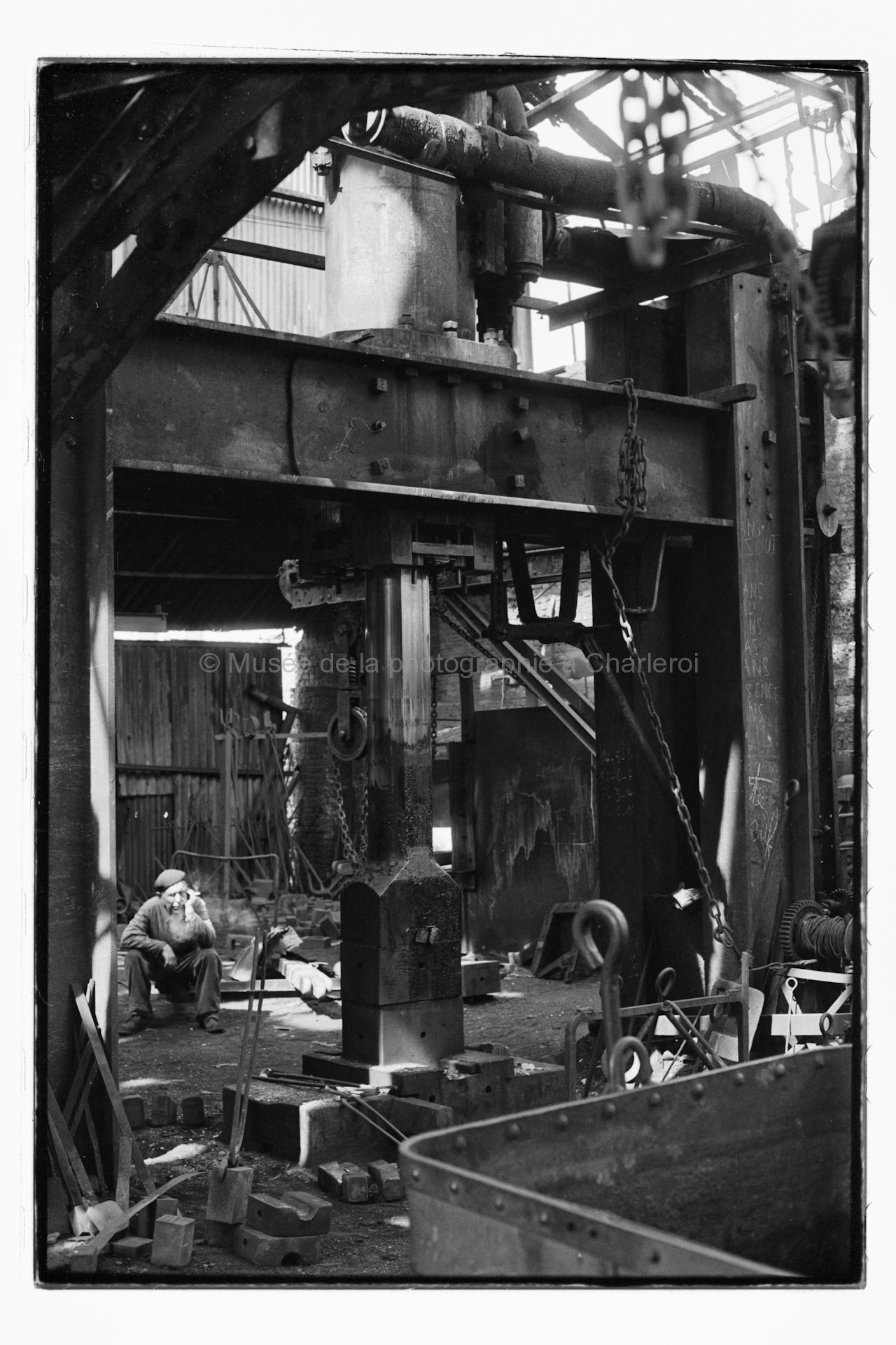 Ouvrier assis au repos dans un atelier des Forges